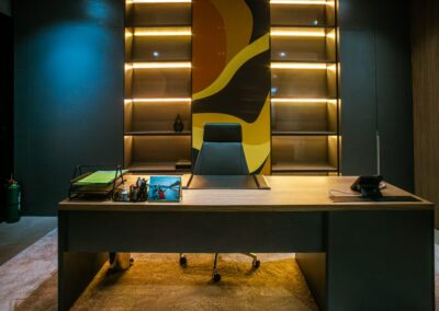 Executive office desk with shelving, accent lighting, and a high-back chair.