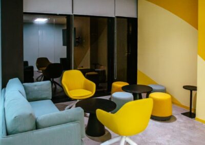 Lounge seating with a sofa, two yellow chairs, and a round table.