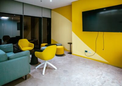 Lounge seating with a sofa, two yellow chairs, and a round table.