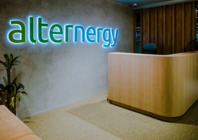 Modern office reception area with “alternergy” illuminated wall signage.