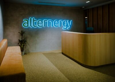 Modern office reception area with “alternergy” illuminated wall signage.
