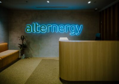 Modern office reception area with “alternergy” illuminated wall signage.