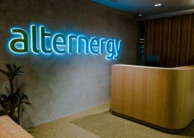 Modern office reception area with “alternergy” illuminated wall signage.