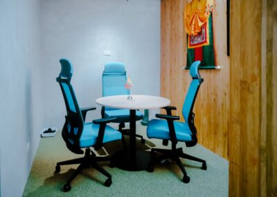 Small meeting room with a round table and three office chairs.