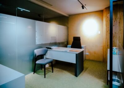 Private office with a desk, chair, and glass wall.