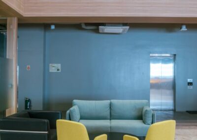 Office lounge area with a sofa, two chairs, and a small round table.