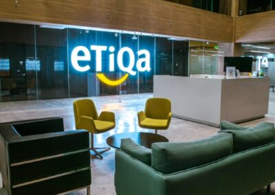 Office atrium with hanging sculptures and Etiqa signage.