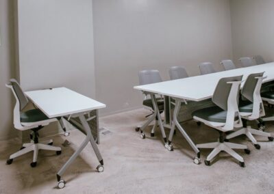 Training room with long desk and rolling chairs.