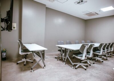 Training room with long desk and rolling chairs.
