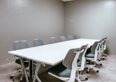 Training room with long desk and rolling chairs.