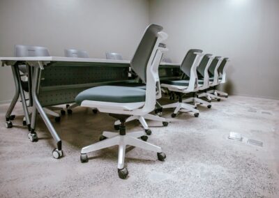 Training room with long desk and rolling chairs.