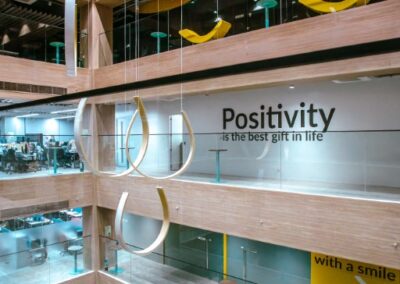 Office atrium with hanging sculptures and “Positivity” wall text