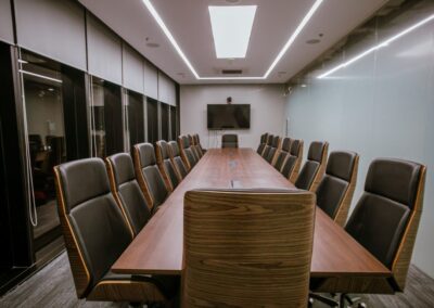 Conference room with a long table and high-back office chairs.