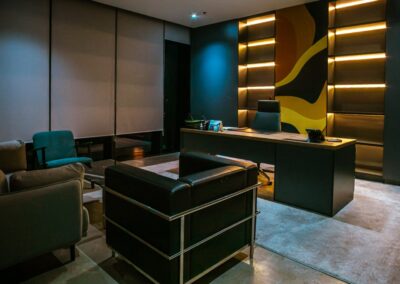 Executive office desk with shelving, accent lighting, and a high-back chair.