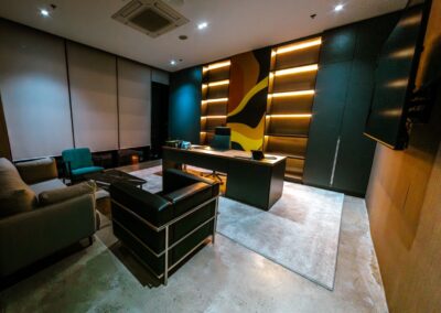 Executive office desk with shelving, accent lighting, and a high-back chair.