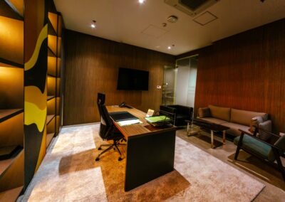 Executive office with desk, seating area, and wood-paneled walls.